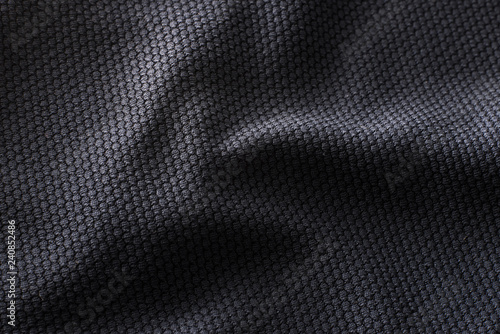 Close-up polyester fabric texture of black athletic shirt