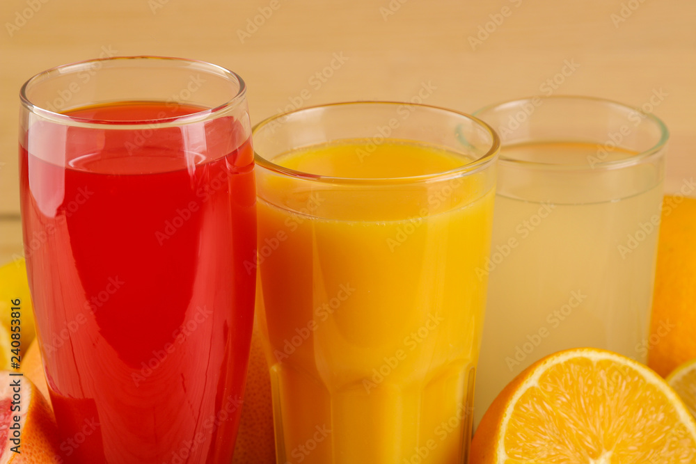 Citrus juices. orange, lemon and grapefruit juice with fresh fruits on a natural wooden background. Citrus juices. orange, lemon and grapefruit juice with fresh fruits on a natural wooden background.