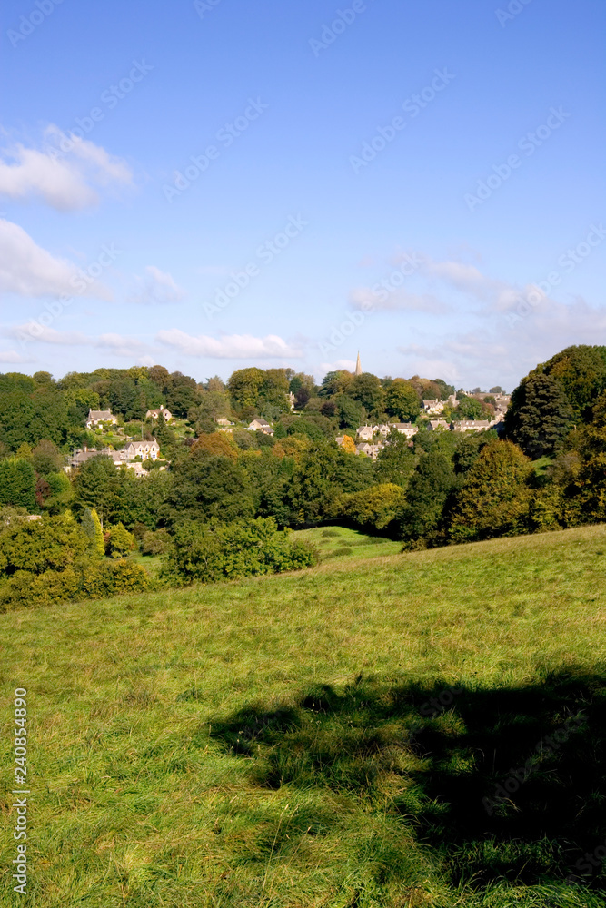 England, Cotswolds, Gloucestershire, early signs of Autumn in the trees around pictureque Bisley village