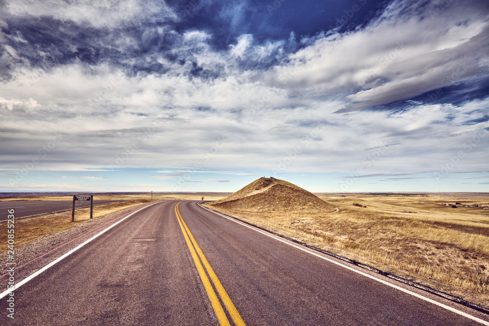 Scenic road by Pinnacles Overlook in Badlands National Park, color toned picture, South Dakota, USA.