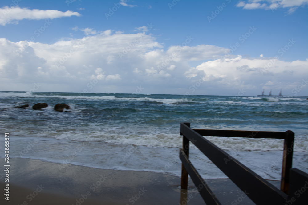 Waves crashing on shoreline with moody dramatic sky