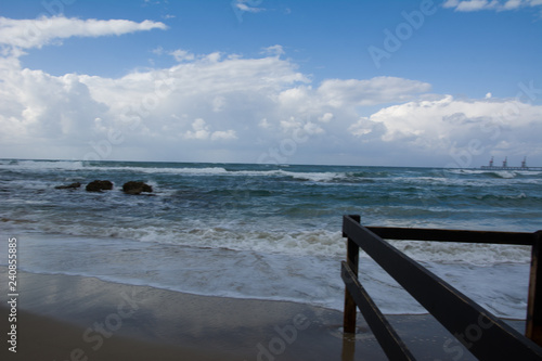 Waves crashing on shoreline with moody dramatic sky