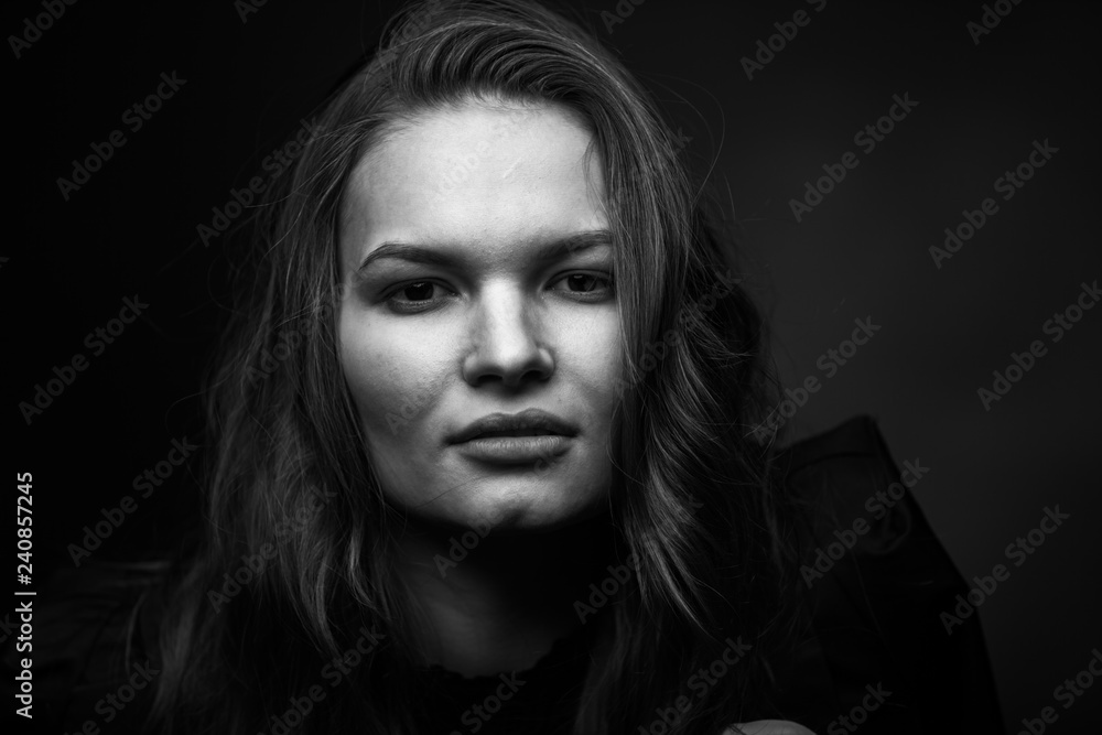 Dramatic black and white portrait of a beautiful girl on a dark background Dramatic black and white portrait of a beautiful girl on a dark background