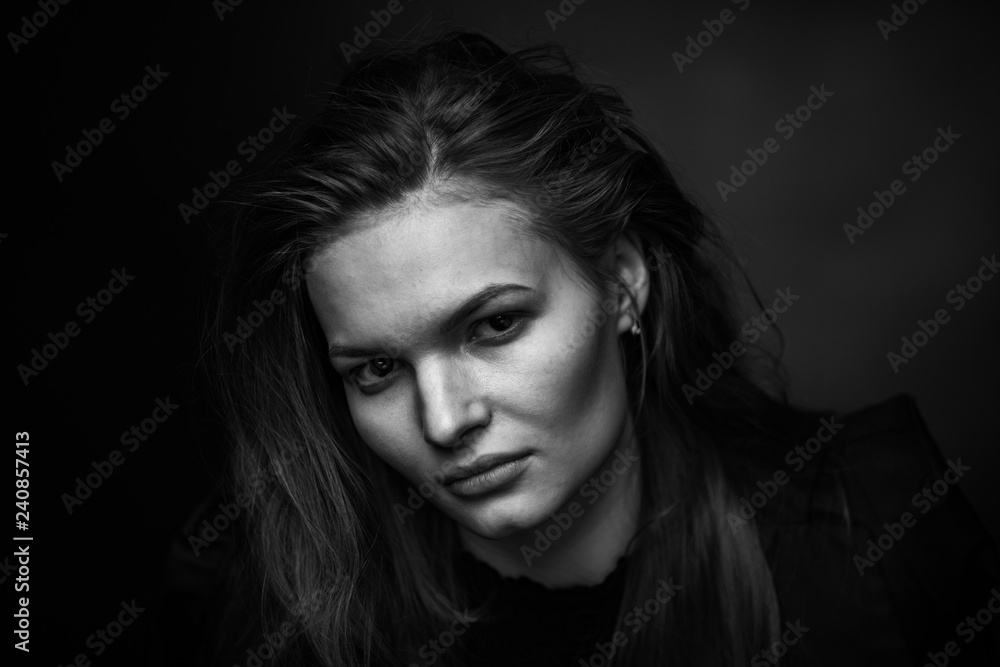 Dramatic black and white portrait of a beautiful girl on a dark background