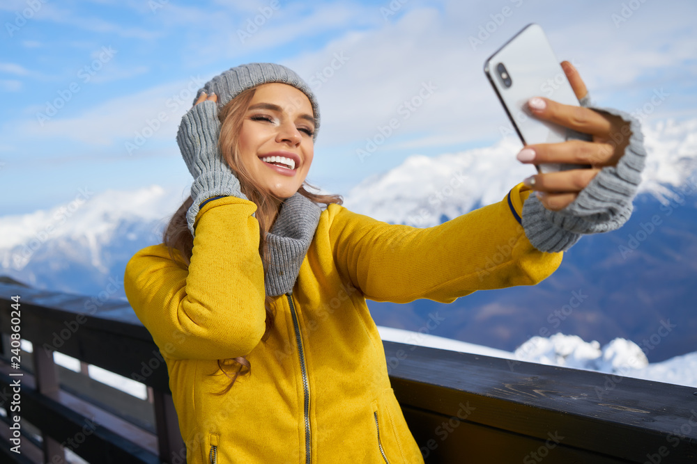 © ZoomTeam - Woman skier making selfie photo on the background of snowy high mountains and © ZoomTeam - Woman skier making selfie photo on the background of snowy high mountains and