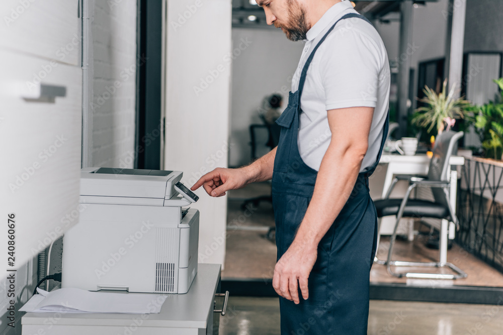 cropped image of male handyman repairing copy machine in modern office cropped image of male handyman repairing copy machine in modern office