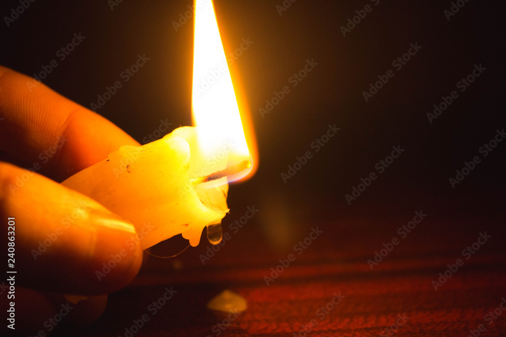 Drops of wax dripping from a burning candle in hand Stock Photo | Adobe  Stock