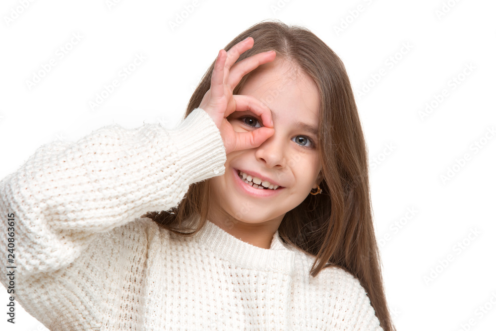 portrait of cute little kid girl in stylish knitted sweater looking at camera and smiling, standing against white studio wall. Kids fashion concept portrait of cute little kid girl in stylish knitted sweater looking at camera and smiling, standing against white studio wall. Kids fashion concept