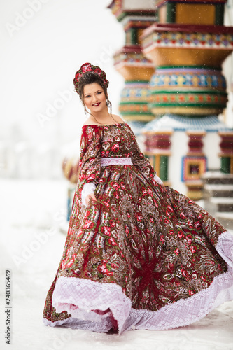 Beautiful happy woman is wearing traditional russian costume in