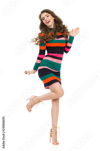 Fashion Model In Striped Dress Is Standing On One Leg And Laughing