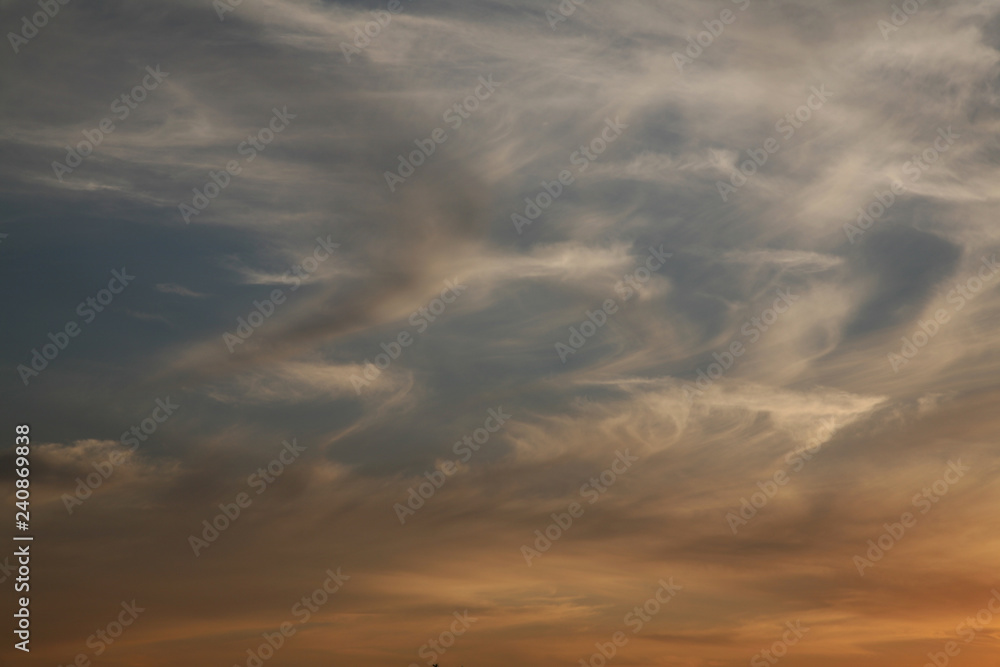 Sky background beautiful image. Abstract background is decorated with different types of clouds. Sunset in the evening sky. The sun  rays illuminate the clouds.