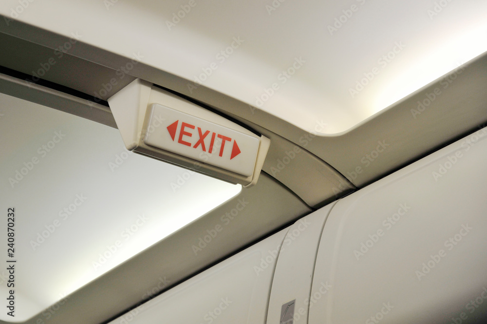 Close up of exit sign in passenger airplane. Close up of exit sign in passenger airplane.