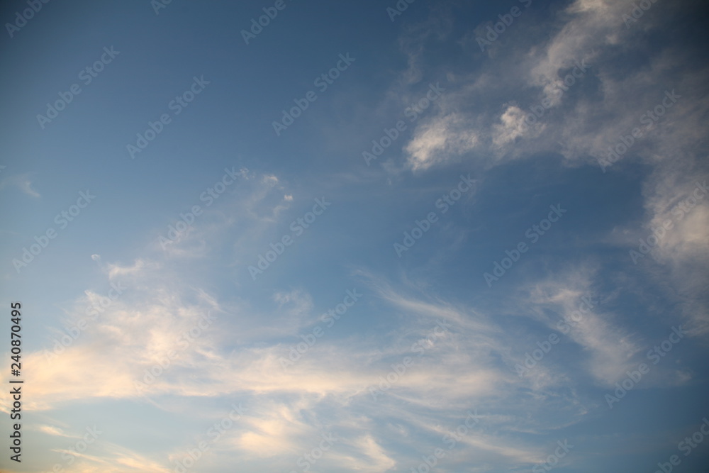 The bright background of the sky is covered with beautiful clouds. Very light clouds and sky soar across the horizon. Wind accelerates paint with a blue background image of nature.