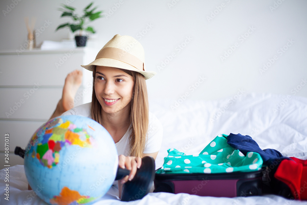 Vacation. Woman Who is Preparing for Rest. Young Beautiful Girl Sits on the Bed. Portrait of a Smiling Woman. Happy Girl Goes On Vacation Vacation. Woman Who is Preparing for Rest. Young Beautiful Girl Sits on the Bed. Portrait of a Smiling Woman. Happy Girl Goes On Vacation