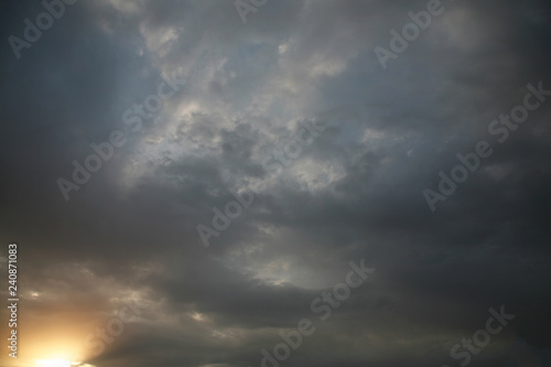 Sky background beautiful image. Abstract background is decorated with different types of clouds. Sunset in the evening sky. The sun rays illuminate the clouds.