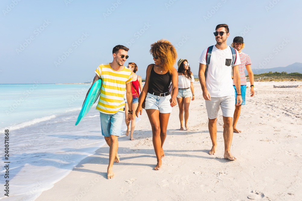 Group of friends walking on the beach, carrying surfboards Group of friends walking on the beach, carrying surfboards