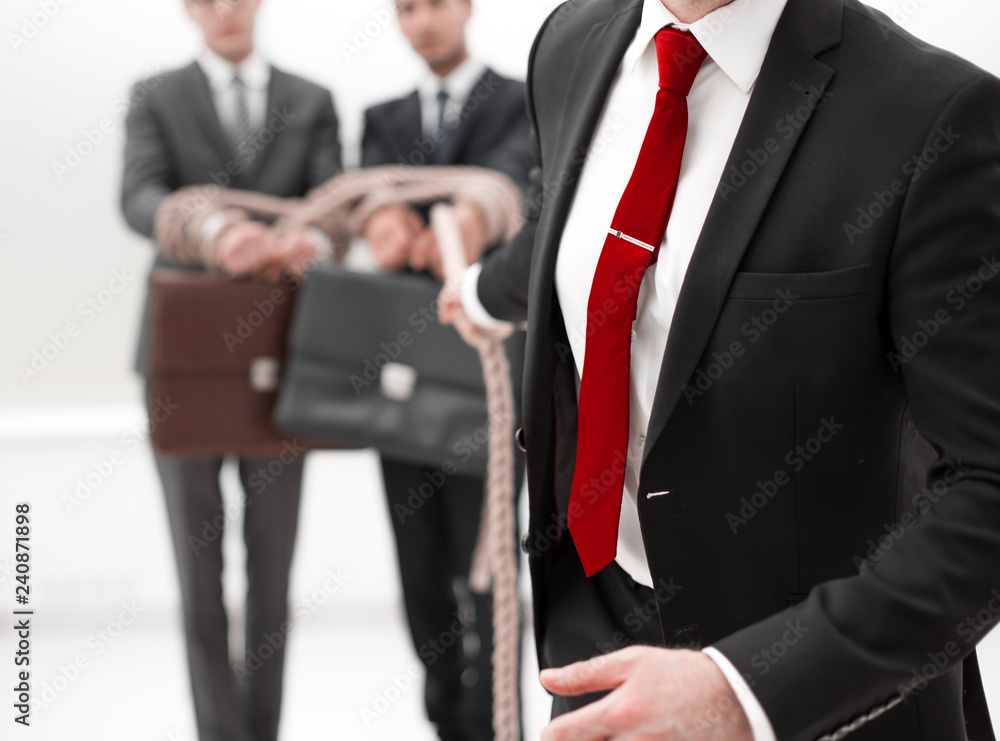 Unrecognizable business people connected with each other with a rope Unrecognizable business people connected with each other with a rope