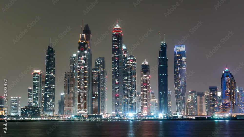 Fototapeta premium Dubai Marina skyline night timelapse as seen from Palm Jumeirah in Dubai, UAE.