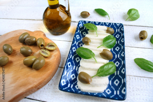 Mozzarella, zielone oliwki i liście bazylii
