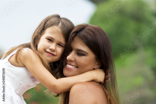 Little cute girl with her mother in summer park 