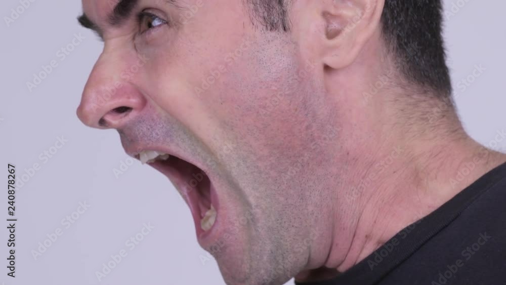 Profile view of stressed man looking angry while screaming