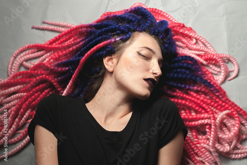 Beautiful young female with unusual hair lies on the floor photo