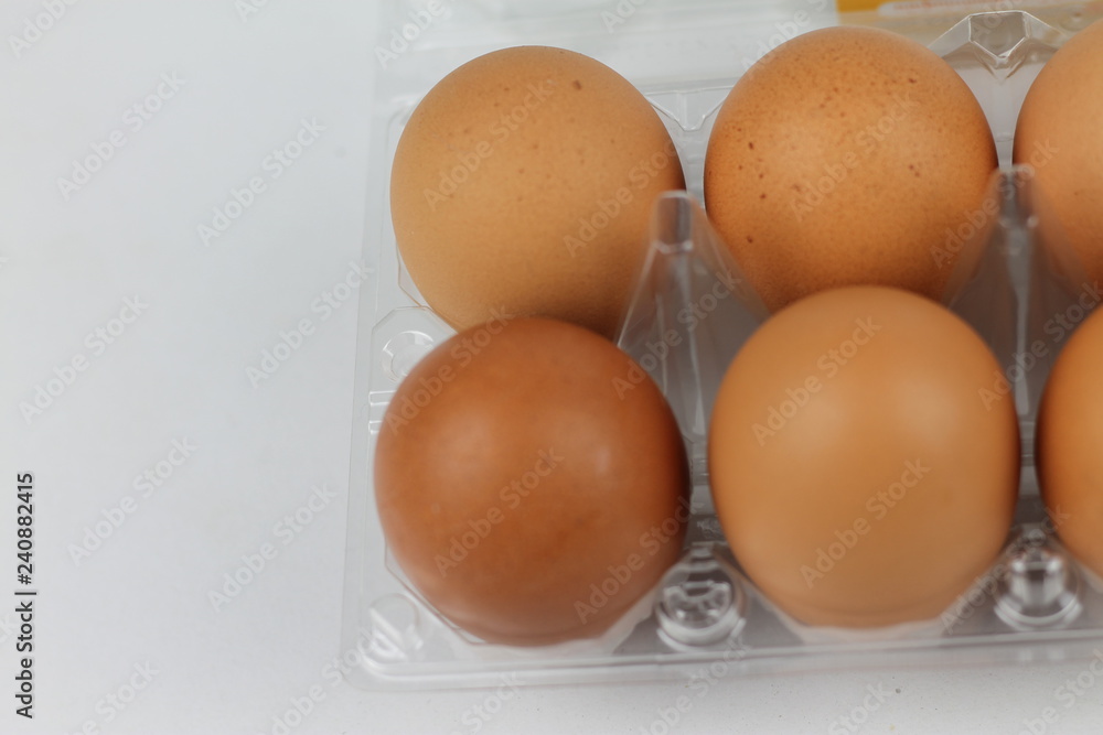 Close-up view of raw chicken eggs in egg box on white white background Close-up view of raw chicken eggs in egg box on white white background