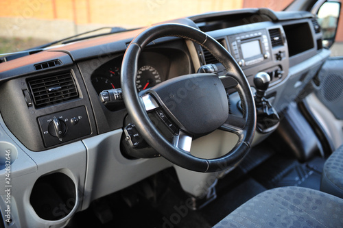 Modern luxury prestige car interior, dashboard, steering wheel. Black perforated leather interior. © ruslan_shramko