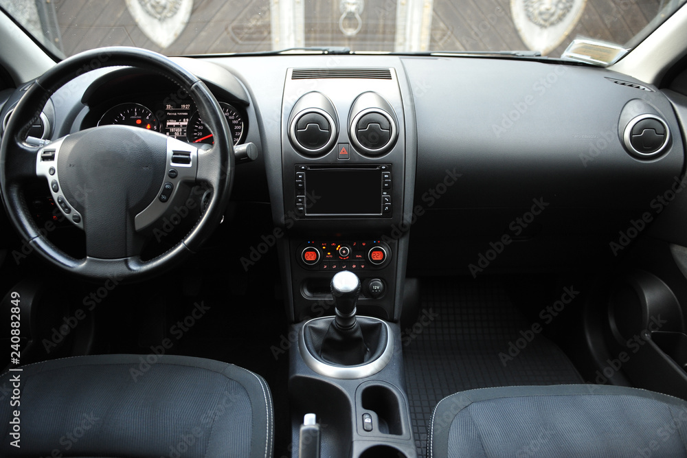 Modern luxury prestige car interior, dashboard, steering wheel. Black perforated leather interior.