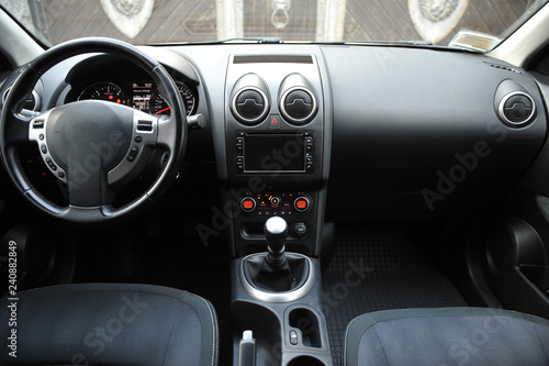 Modern luxury prestige car interior, dashboard, steering wheel. Black perforated leather interior.