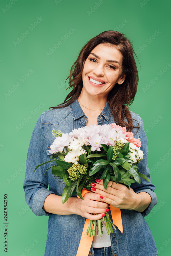smiling attractive woman holding flower bouquet and looking at camera isolated on green smiling attractive woman holding flower bouquet and looking at camera isolated on green