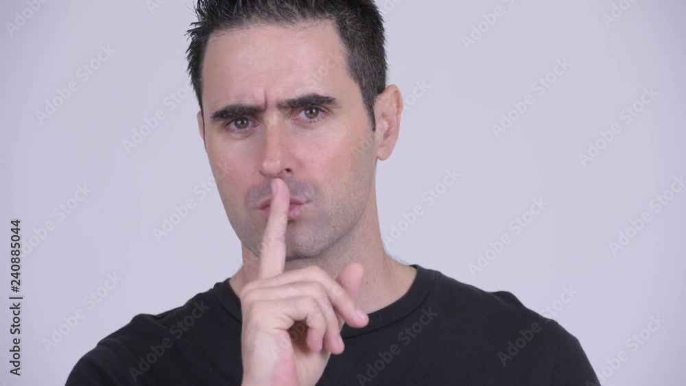 Face of handsome man with finger on lips against white background Face of handsome man with finger on lips against white background