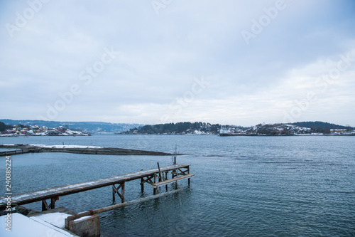 A pier for boats traveling between the Islands around Oslo Norway during the winter overlooking the sea and the Fjord