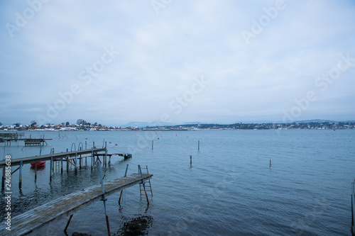 A pier for boats traveling between the Islands around Oslo Norway during the winter overlooking the sea and the Fjord covered by snow