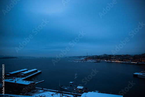 Oslo Norway coast during winter with a large number of docked boats in the center of the city covered with snow © Lukas