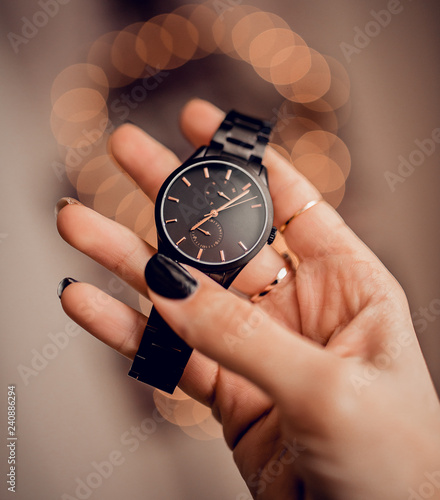 Stylish black watch in woman hand