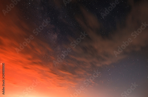 Orange clouds on the sky and milky way galaxy.