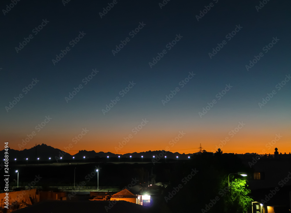 Night in the desert and a beautiful sunset in the sands are visible only the lights in the distance Night in the desert and a beautiful sunset in the sands are visible only the lights in the distance