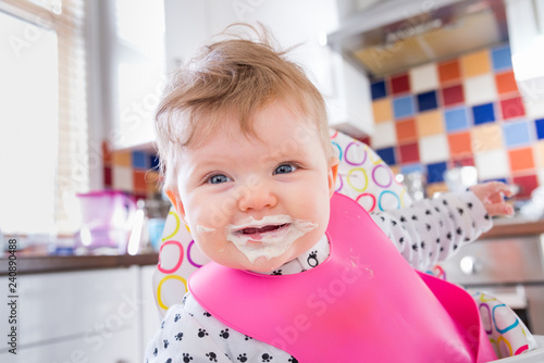 Cuadro en lienzo Six month old baby girl eating messy porridge