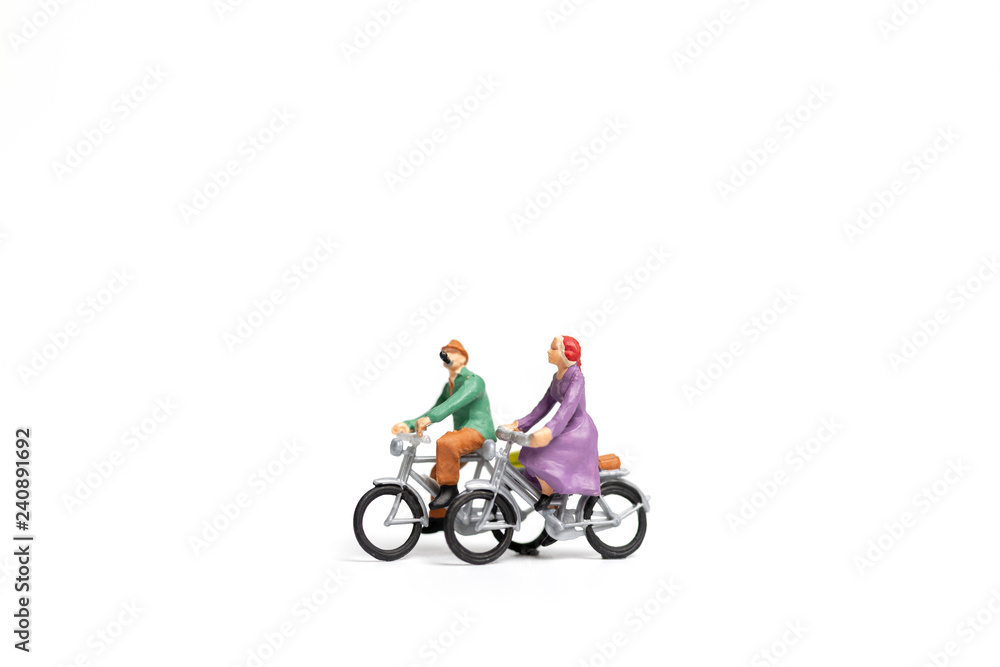 Fototapeta premium Miniature people : Couple ride bicycle on white background