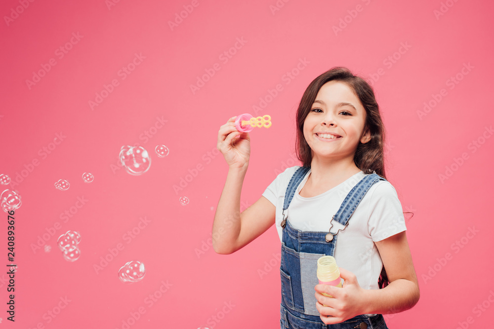 joyful kid standing near soap bubbles isolated on pink joyful kid standing near soap bubbles isolated on pink