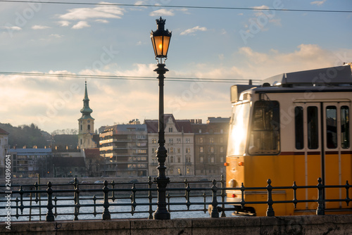 Photography Budapest riverfront, blurred hunker tram with sunlight reflecting in widow movin
