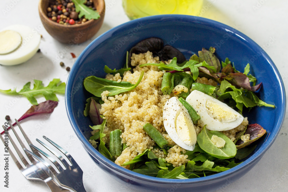 Diet menu, Vegan food. Healthy salad with quinoa, arugula, green Beans and Eggs on a white stone table. Diet menu, Vegan food. Healthy salad with quinoa, arugula, green Beans and Eggs on a white stone table.