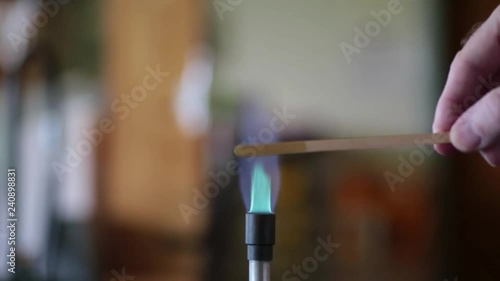 Copper solution burning on a wooden splint in a bunsen burner flame.