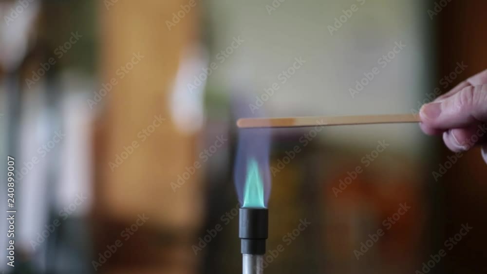 Sodium solution burning on a wooden splint in a bunsen burner flame