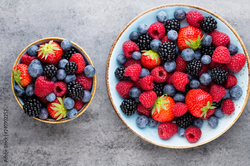 Fototapeta Naklejka Na Ścianę i Meble -  Fresh berry salad on blue dishes. Vintage wooden background.