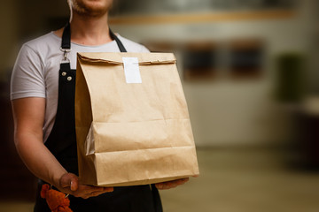 Diverse of paper containers for takeaway food. Delivery man is carrying