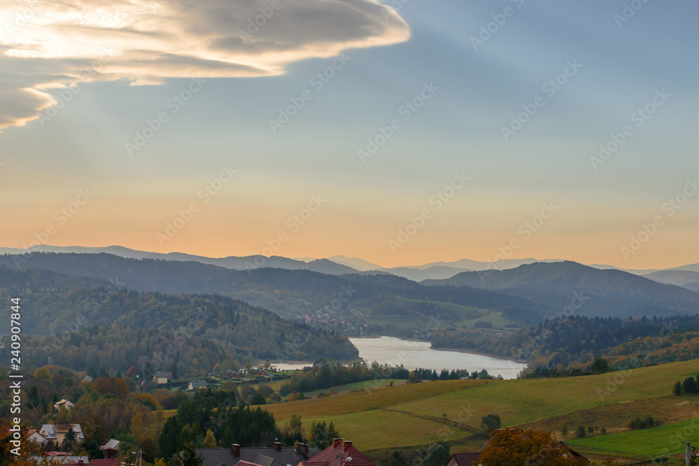 Fototapeta premium Polanczyk, Bieszczady Mountains, Poland: Sun rising over mountains. Views from near hill. In background Solina Lake.