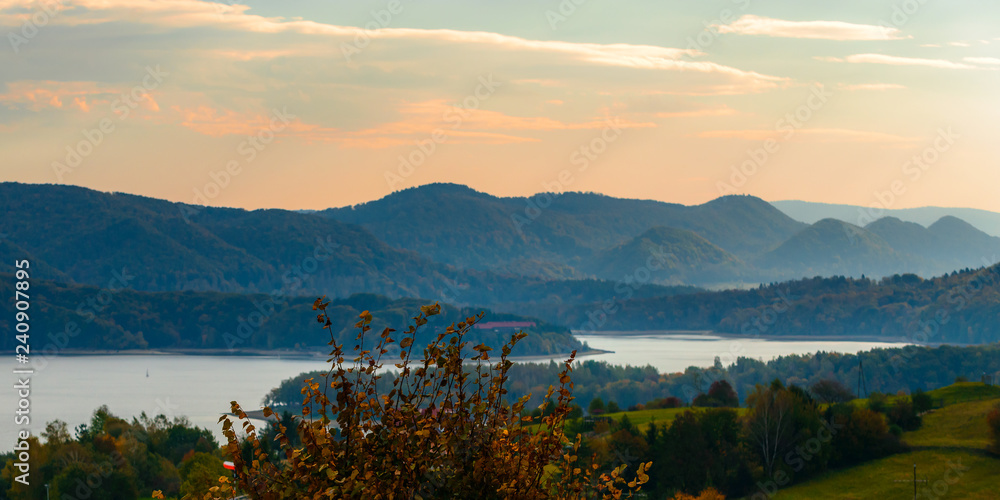 Fototapeta premium Polanczyk, Bieszczady Mountains, Poland: Sun rising over mountains. Views from near hill. In background Solina Lake.