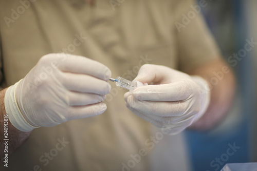 Dentist doctor hands in protective latex gloves with a special dental tool close-up